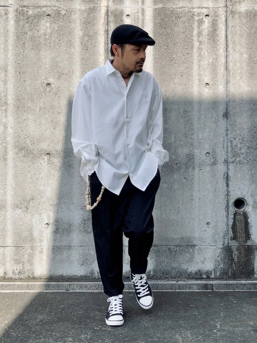 ホワイト系のシャツ/ブラウス、ブラック系のスラックス、ブラック系のスニーカーを着用したメンズの春コーディネートの2枚目の写真