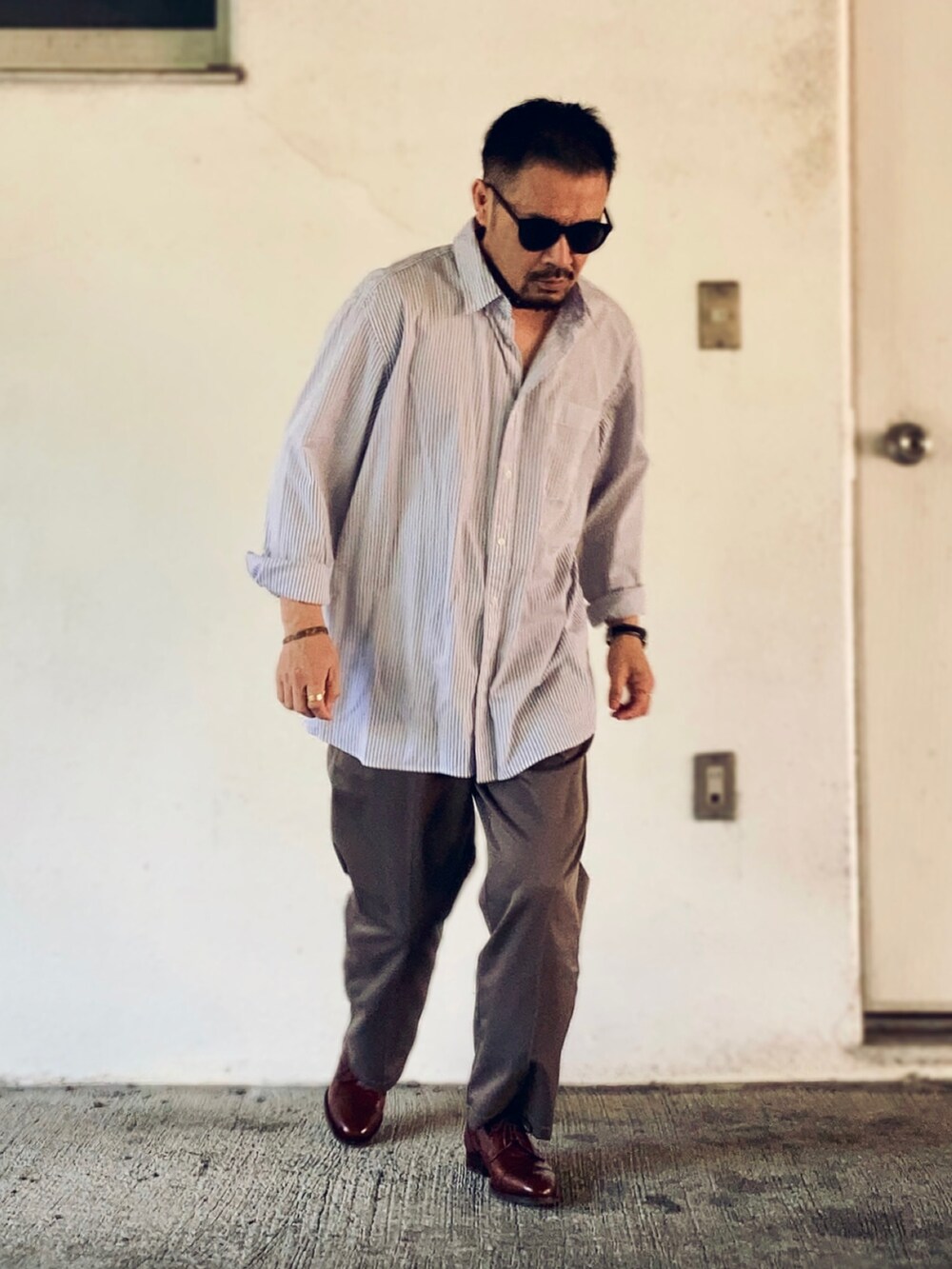 グレー系のシャツ/ブラウス、グレー系のスラックス、ブラウン系のドレスシューズを着用したメンズの春コーディネートの2枚目の写真