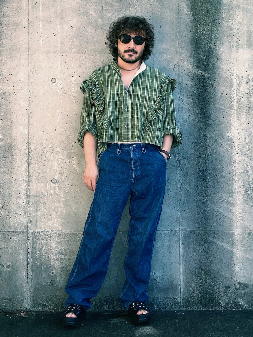 ブルー系のデニムパンツ、グリーン系のシャツ/ブラウス、ブラック系のサンダルを着用したメンズの夏コーディネートの3枚目の写真