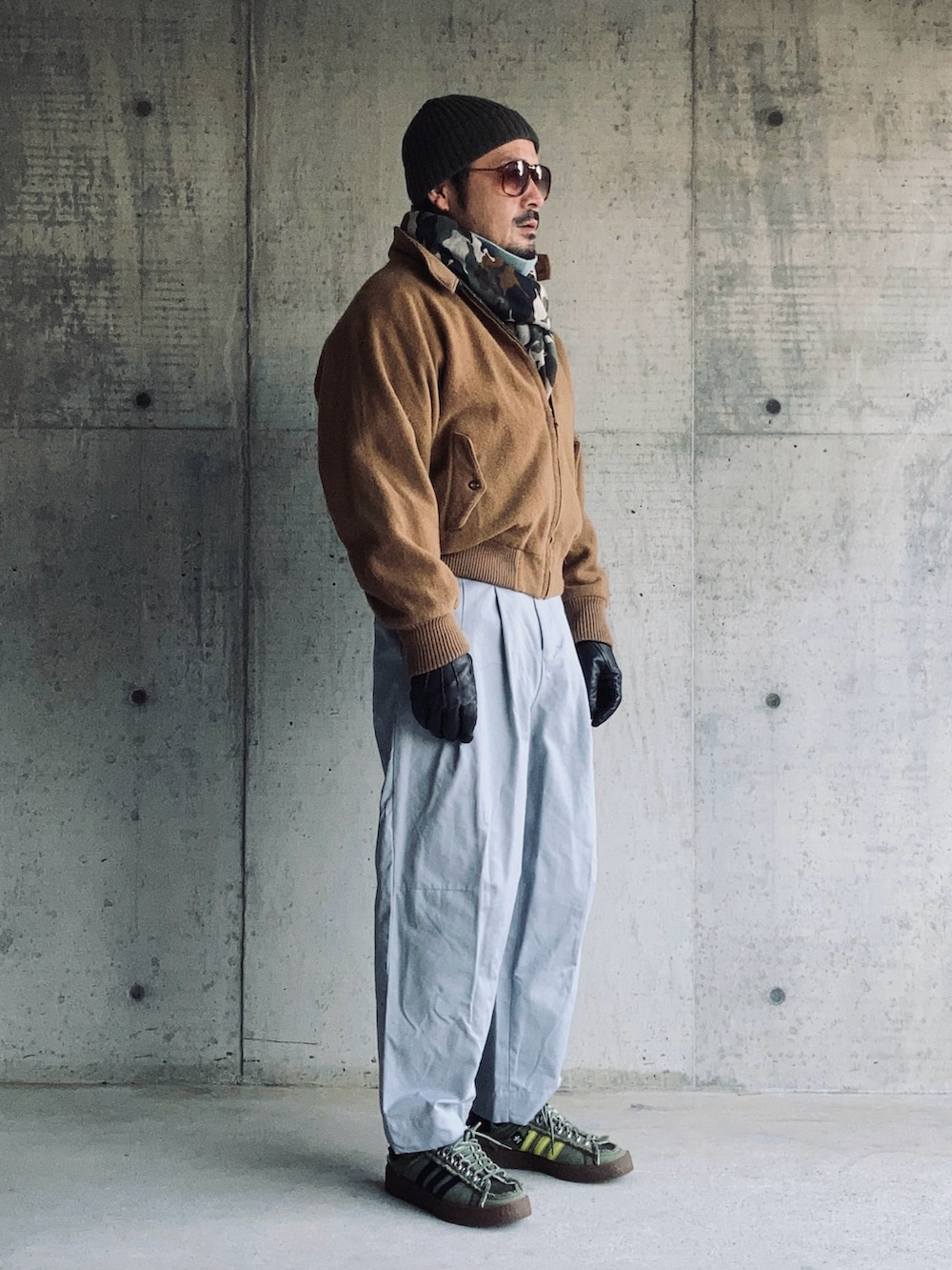 ブルー系のニット/セーター、ブラウン系のブルゾン、グレー系のパンツを着用したメンズの冬コーディネートの3枚目の写真