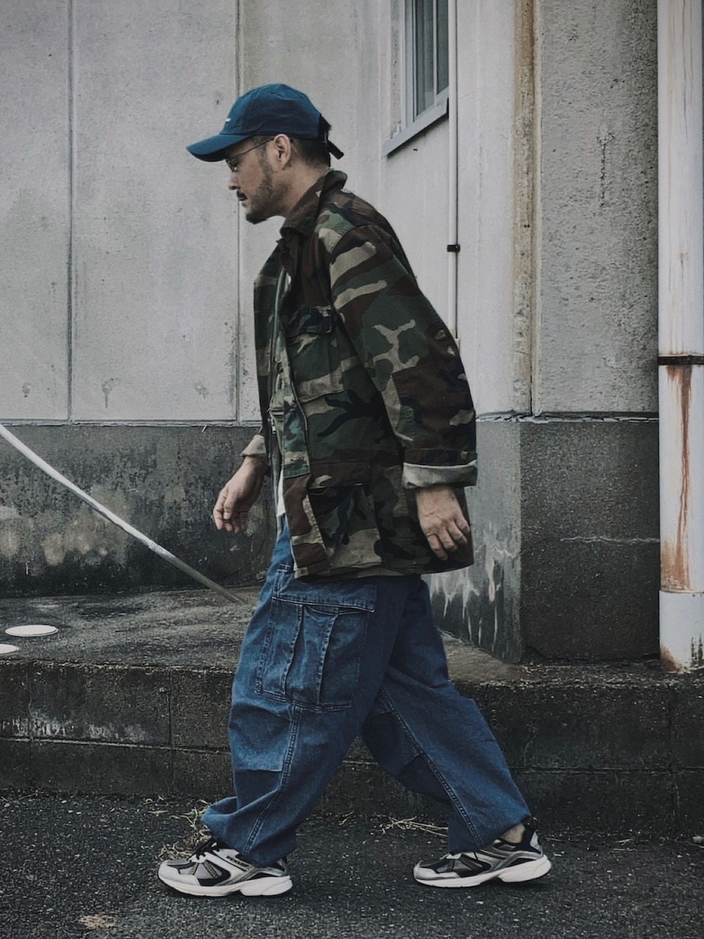 グリーン系のベスト、その他のミリタリージャケット、ブルー系のカーゴパンツを着用したメンズの秋コーディネートの3枚目の写真