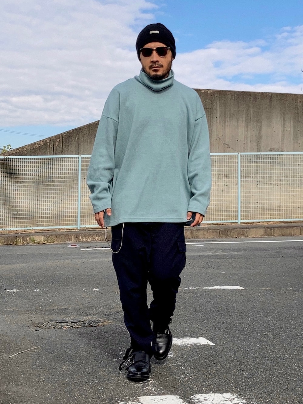 ブルー系のニット/セーター、ブラック系のその他パンツ、ブラック系のドレスシューズを着用したメンズの秋コーディネートの3枚目の写真