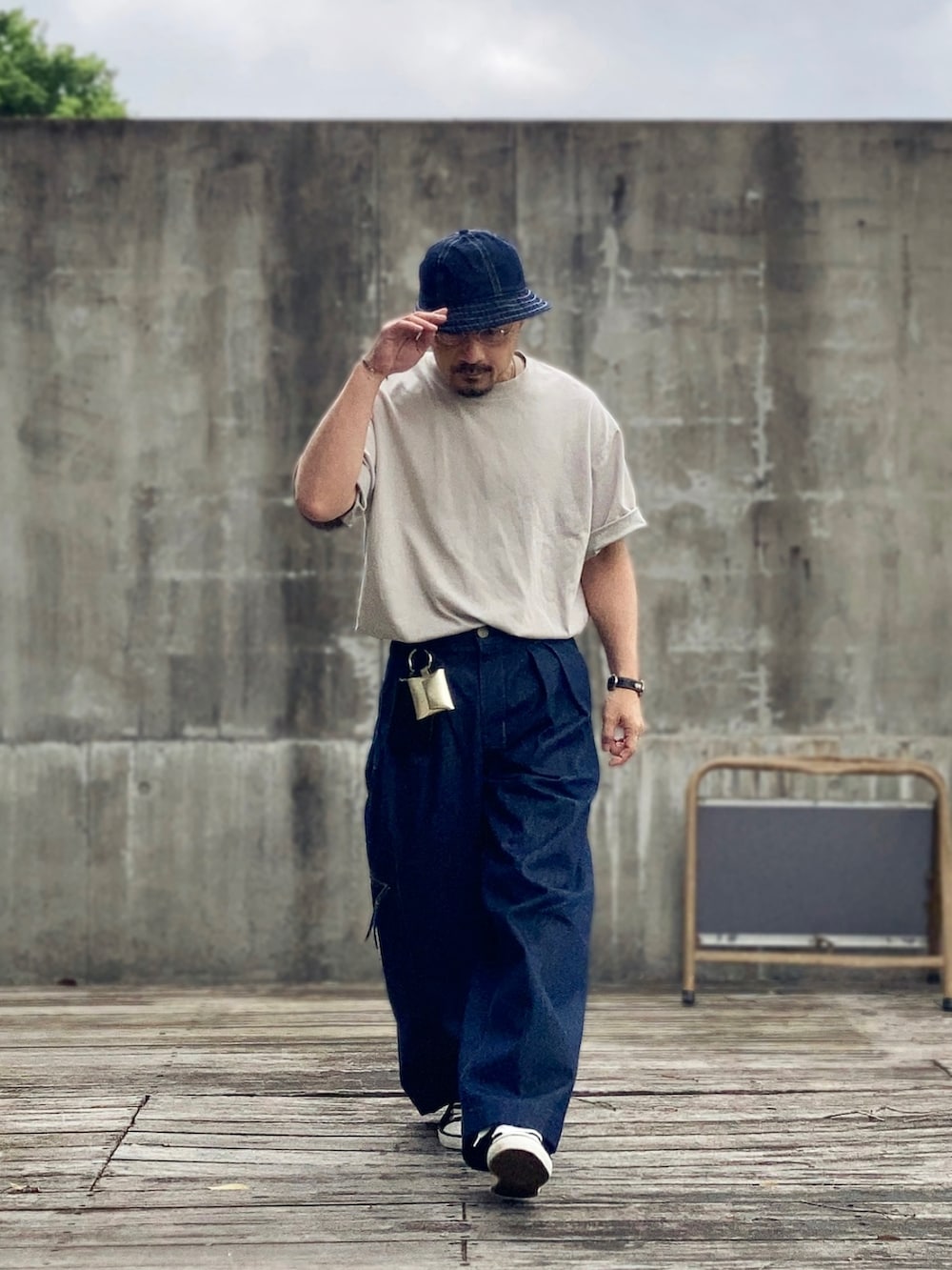 グレー系のTシャツ/カットソー、ブルー系のデニムパンツ、ブラック系のスニーカーを着用したメンズの春コーディネートの4枚目の写真