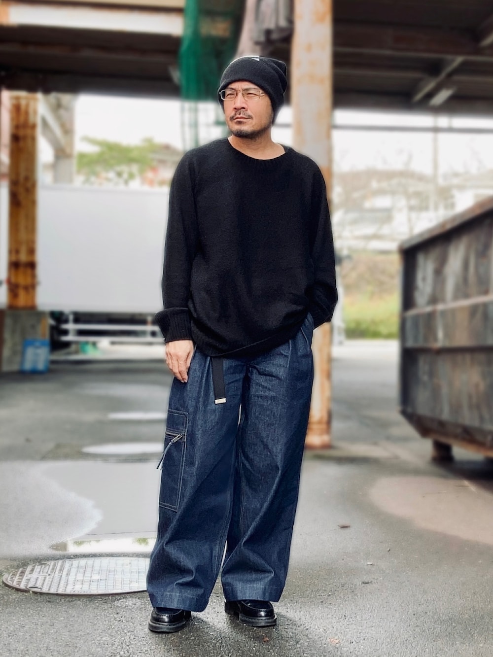 ブラック系のニット/セーター、ブルー系のデニムパンツ、ブラック系のローファーを着用したメンズの秋コーディネートの2枚目の写真