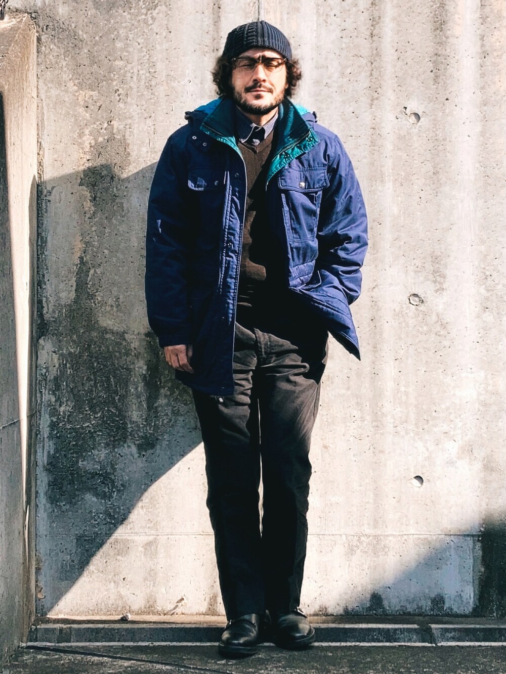 ブルー系のその他アウター、ブラウン系のニット/セーター、ブラック系のスラックスを着用したメンズの冬コーディネートの2枚目の写真