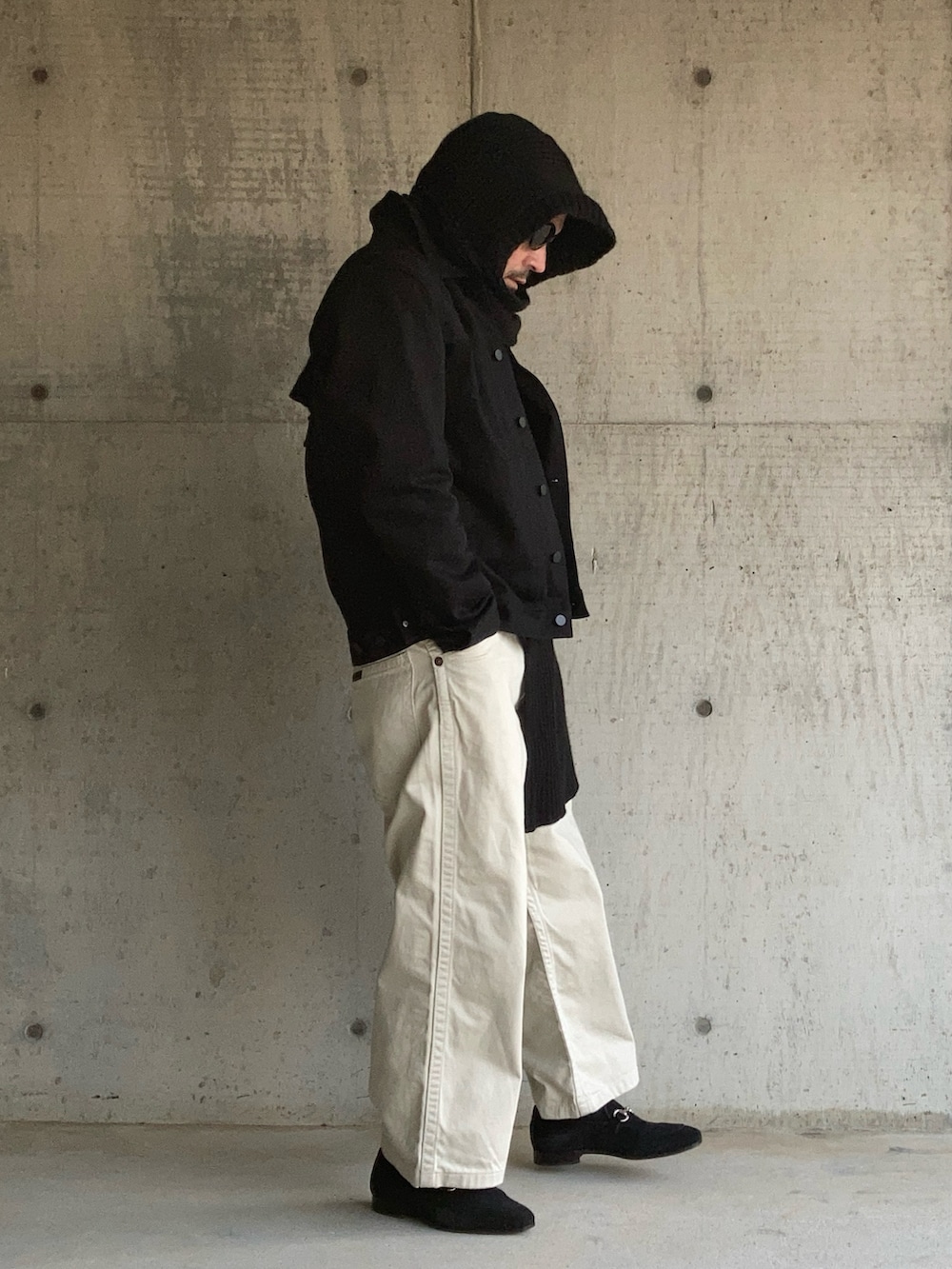 ブラック系のニット/セーター、ブラック系のデニムジャケット、ホワイト系のデニムパンツを着用したメンズの冬コーディネートの2枚目の写真