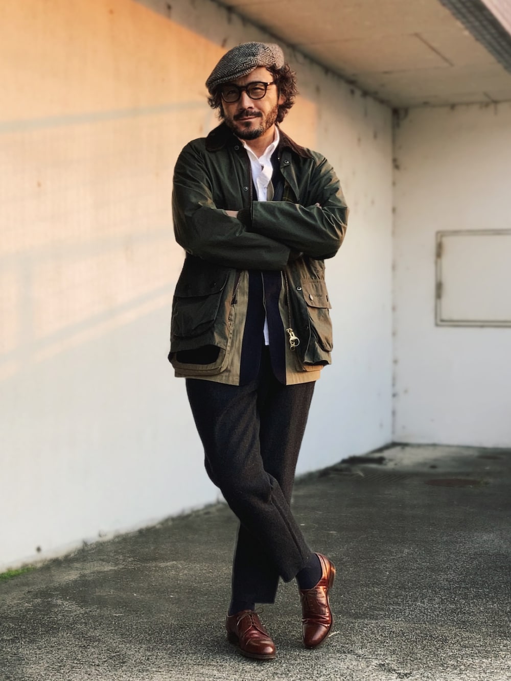 グリーン系のその他アウター、ブラック系のスラックス、ブラウン系のドレスシューズを着用したメンズの春コーディネートの2枚目の写真