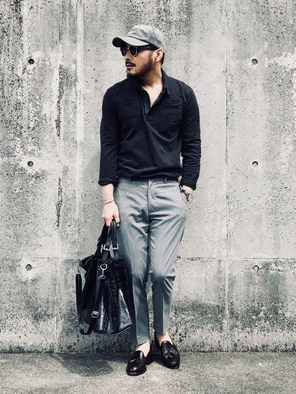 ブラック系のポロシャツ、グレー系のその他パンツ、ブラウン系のローファーを着用したメンズの春コーディネートの2枚目の写真