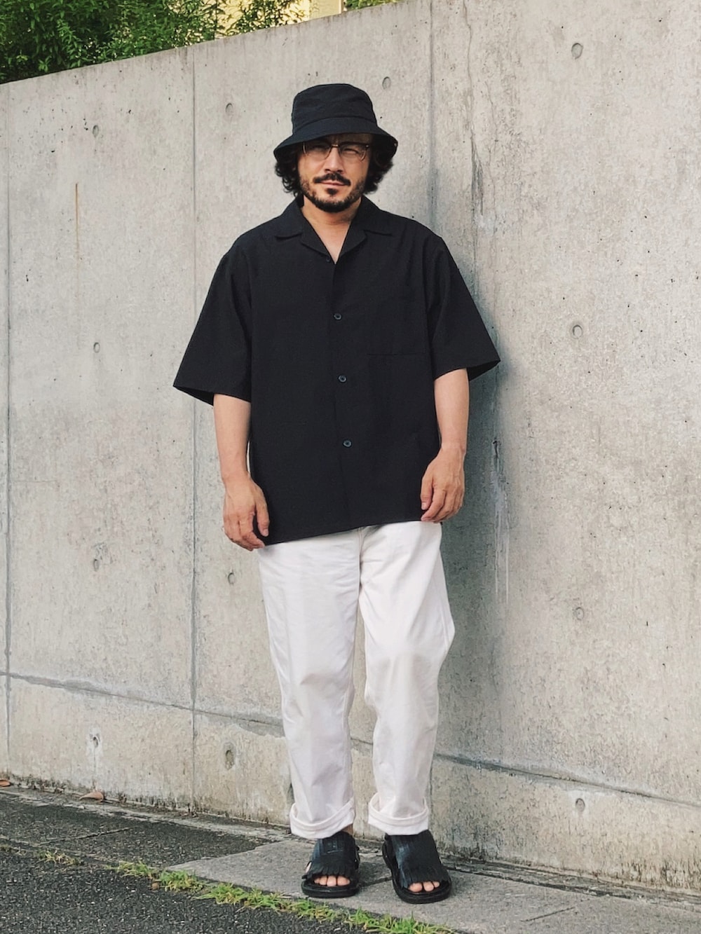 ブラック系のサンダル、ブラック系のシャツ/ブラウス、ホワイト系のデニムパンツを着用したメンズの夏コーディネートの3枚目の写真