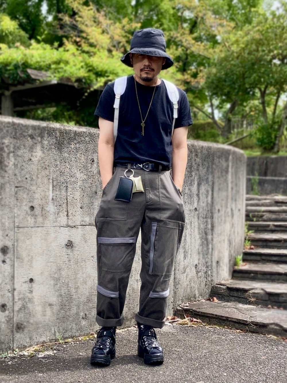 ブラック系のTシャツ/カットソー、グリーン系のその他パンツ、ブラック系のサンダルを着用したメンズの秋コーディネートの3枚目の写真