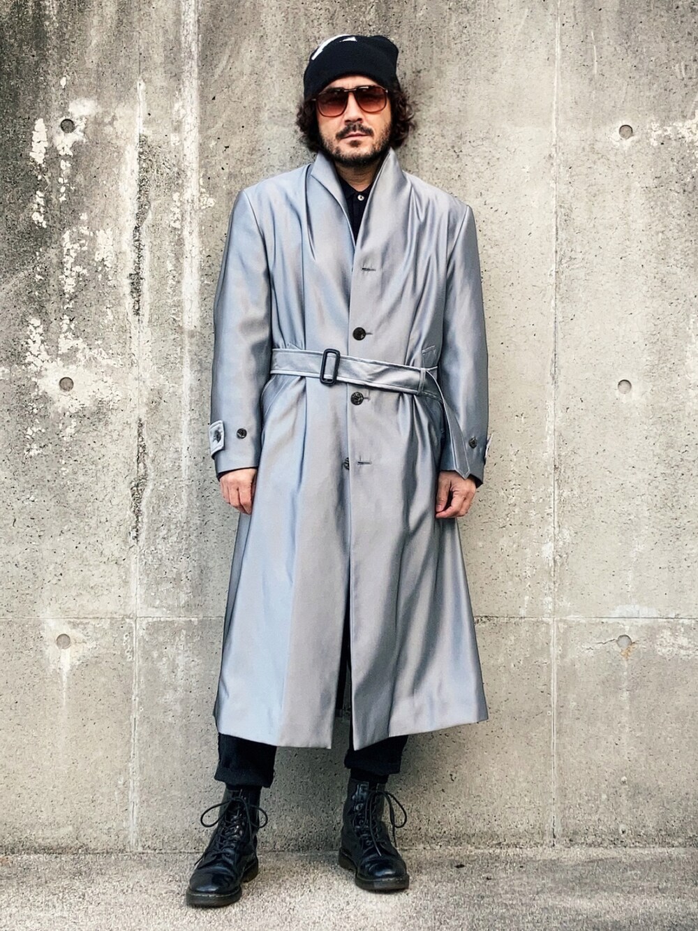 シルバー系のノーカラーコート、ブラック系のスラックス、ブラック系のブーツを着用したメンズの冬コーディネートの2枚目の写真