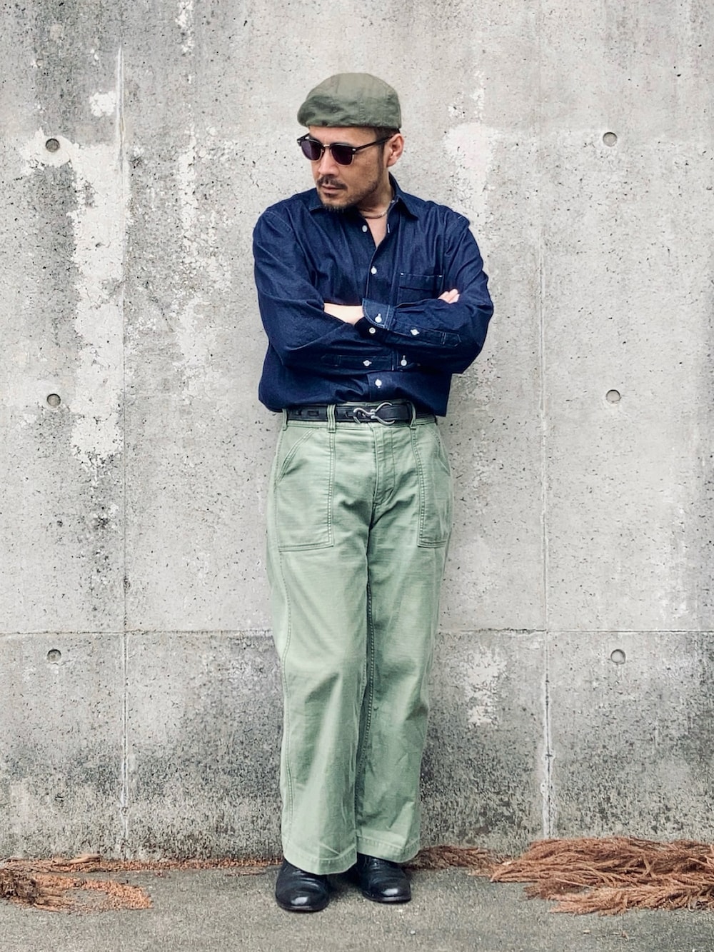 ブルー系のシャツ/ブラウス、グリーン系のパンツ、ブラック系のドレスシューズを着用したメンズの春コーディネートの2枚目の写真