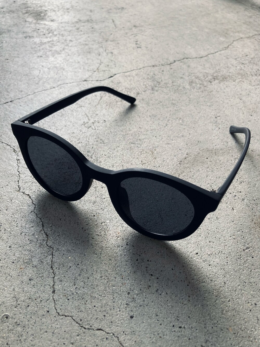 ブルー系のニット/セーター、ベージュ系のトレンチコート、グレー系のスラックスを着用したメンズの春コーディネートの5枚目の写真