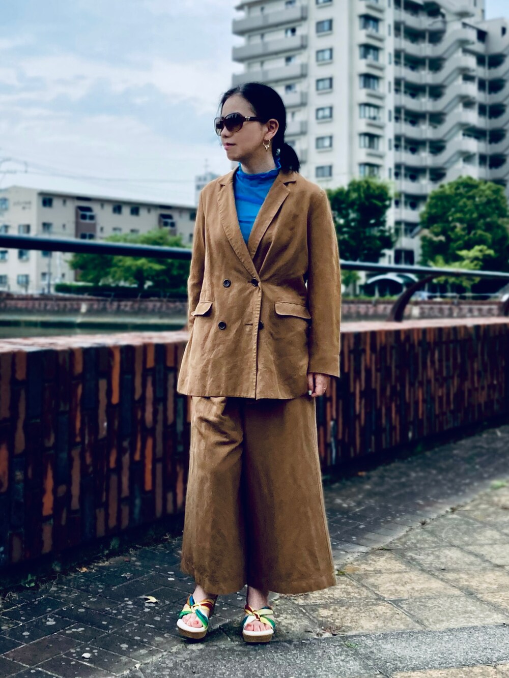 ブルー系のTシャツ/カットソー、その他のサンダル、ブラウン系のセットアップを着用したレディースの夏コーディネートの2枚目の写真