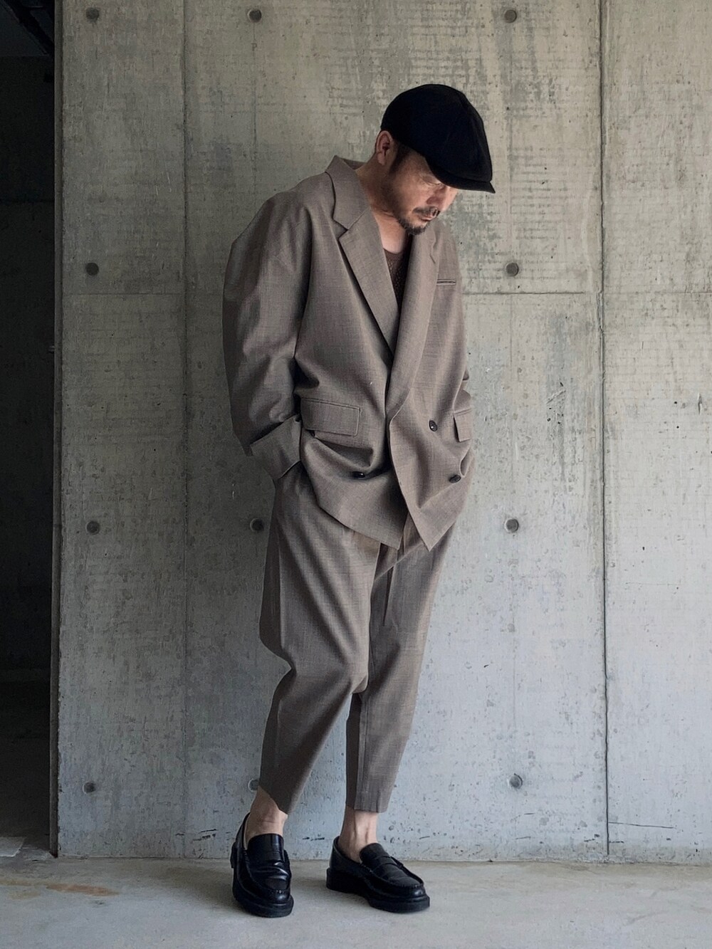 ブラウン系のタンクトップ、ブラウン系のテーラードジャケット、ブラウン系のスラックスを着用したメンズの秋コーディネートの4枚目の写真