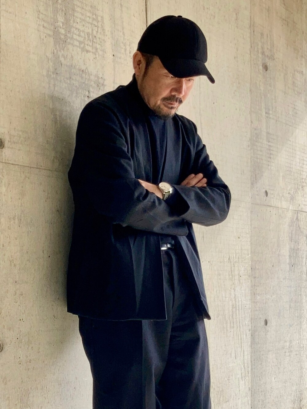 ブラック系のニット/セーター、ブラック系のスラックス、ブラック系のテーラードジャケットを着用したメンズの冬コーディネートの5枚目の写真