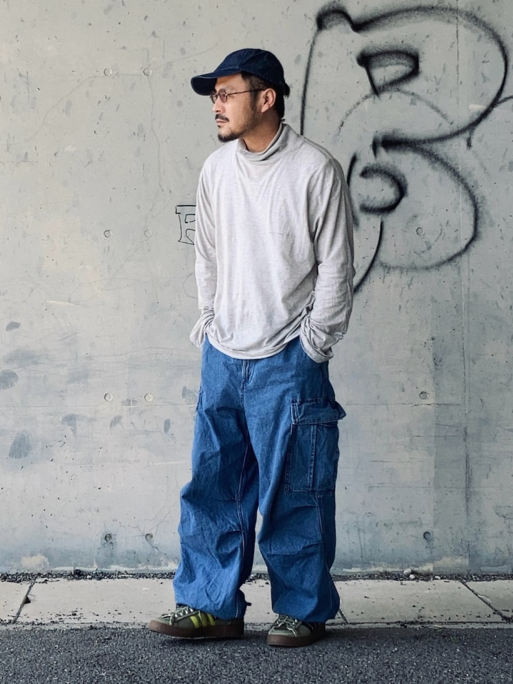 グレー系のTシャツ/カットソー、ブルー系のカーゴパンツ、グリーン系のスニーカーを着用したメンズの春コーディネートの2枚目の写真