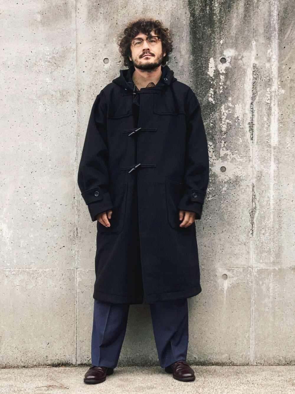 ブラック系のダッフルコート、ベージュ系のセットアップ、ブルー系のスラックスを着用したメンズの秋コーディネートの5枚目の写真