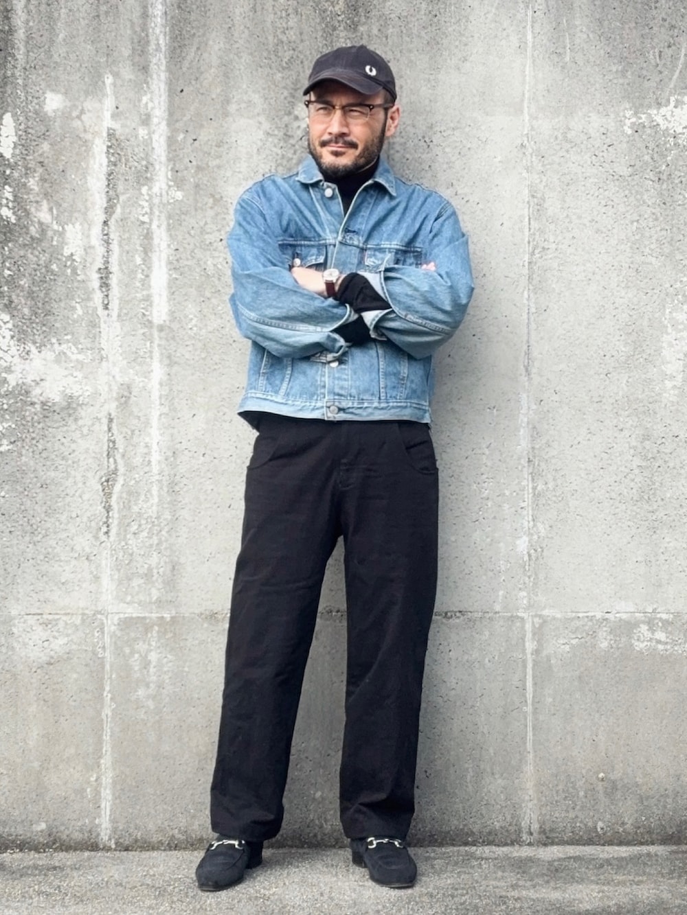 ブラック系のニット/セーター、ブルー系のデニムジャケット、ブラック系のパンツを着用したメンズの冬コーディネートの2枚目の写真