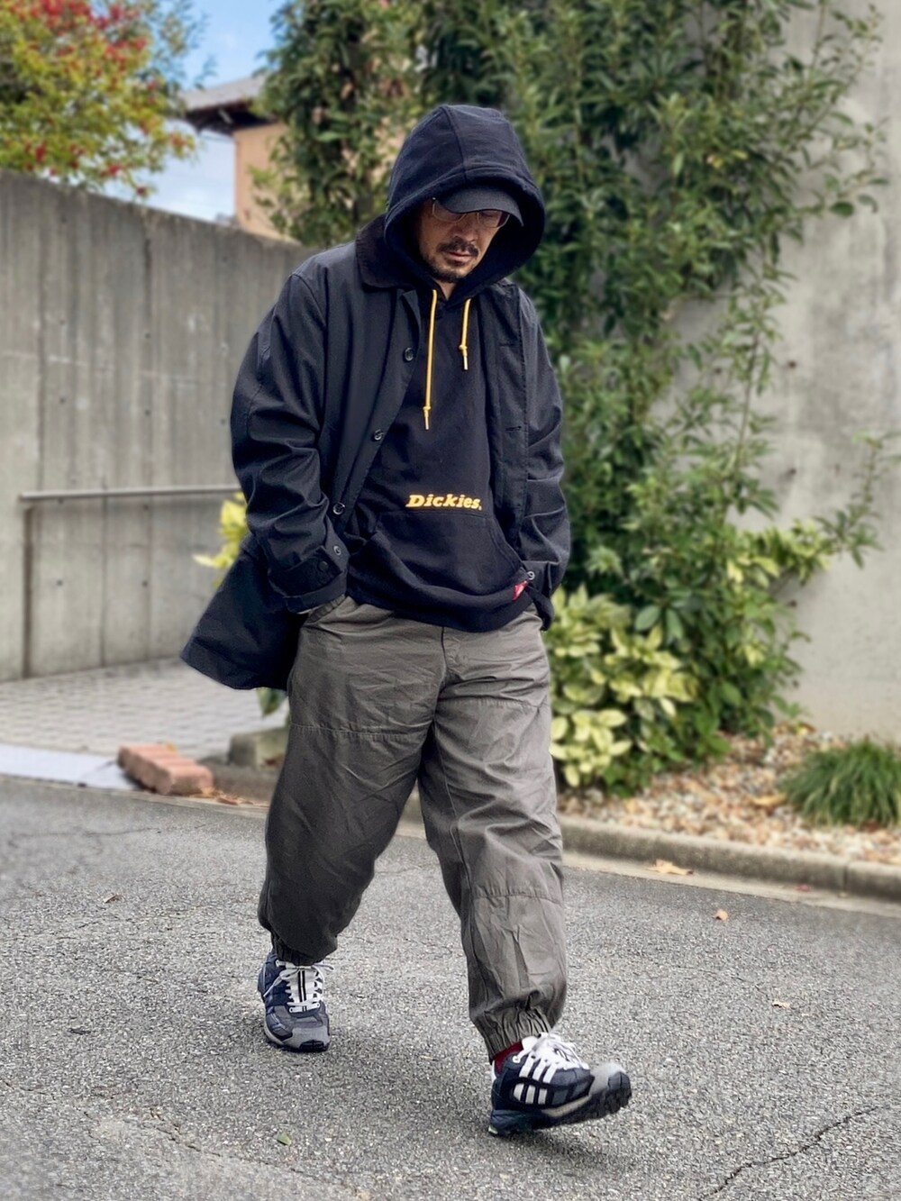 ブラック系のパーカー、ブラック系のナイロンジャケット、グリーン系のその他パンツを着用したメンズの冬コーディネートの2枚目の写真