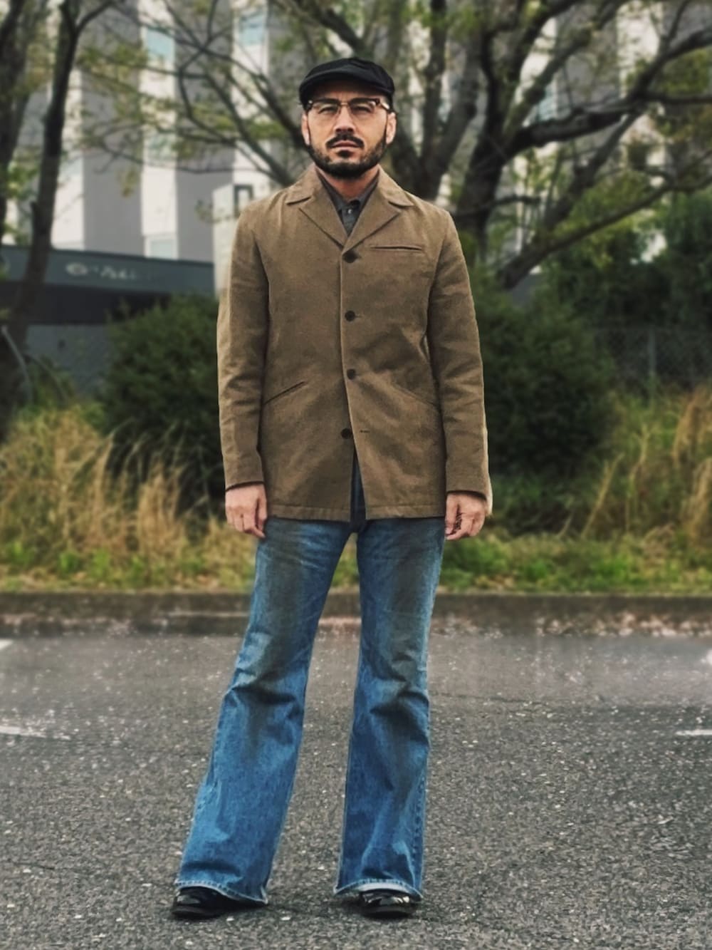 ベージュ系のテーラードジャケット、ブルー系のデニムパンツ、ブラック系のブーツを着用したメンズの春コーディネートの2枚目の写真