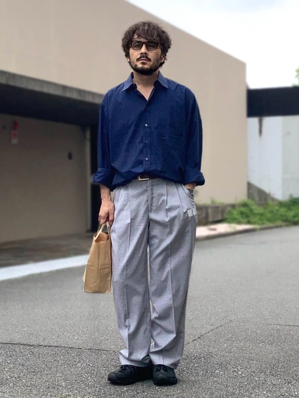 ブルー系のシャツ/ブラウス、グレー系のスラックス、ブラック系のスニーカーを着用したメンズの夏コーディネートの3枚目の写真