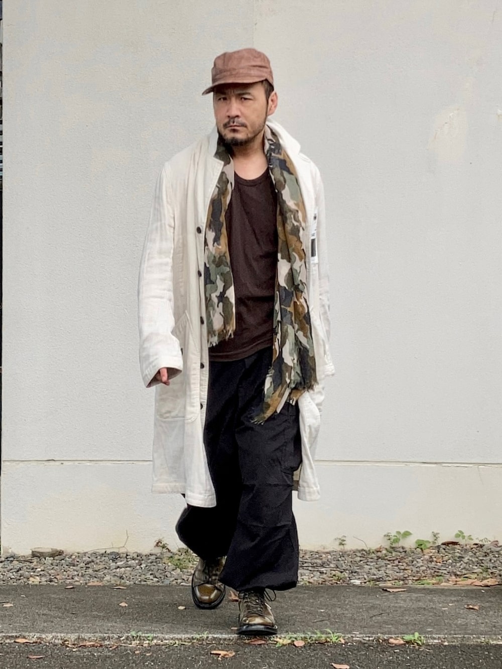 ブラウン系のタンクトップ、ホワイト系のダウンジャケット/コート、ブラック系のカーゴパンツを着用したメンズの秋コーディネートの3枚目の写真