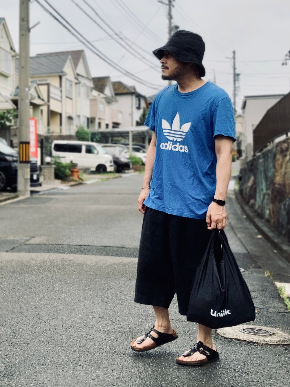ブルー系のTシャツ/カットソー、ブラック系のその他パンツ、ブラック系のサンダルを着用したメンズの夏コーディネートの2枚目の写真