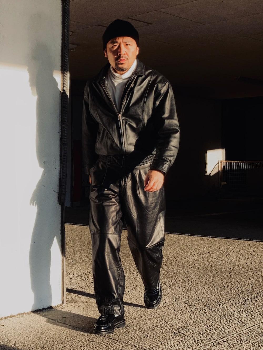 ホワイト系のTシャツ/カットソー、ブラック系のブルゾン、ブラック系のその他パンツを着用したメンズの冬コーディネートの3枚目の写真