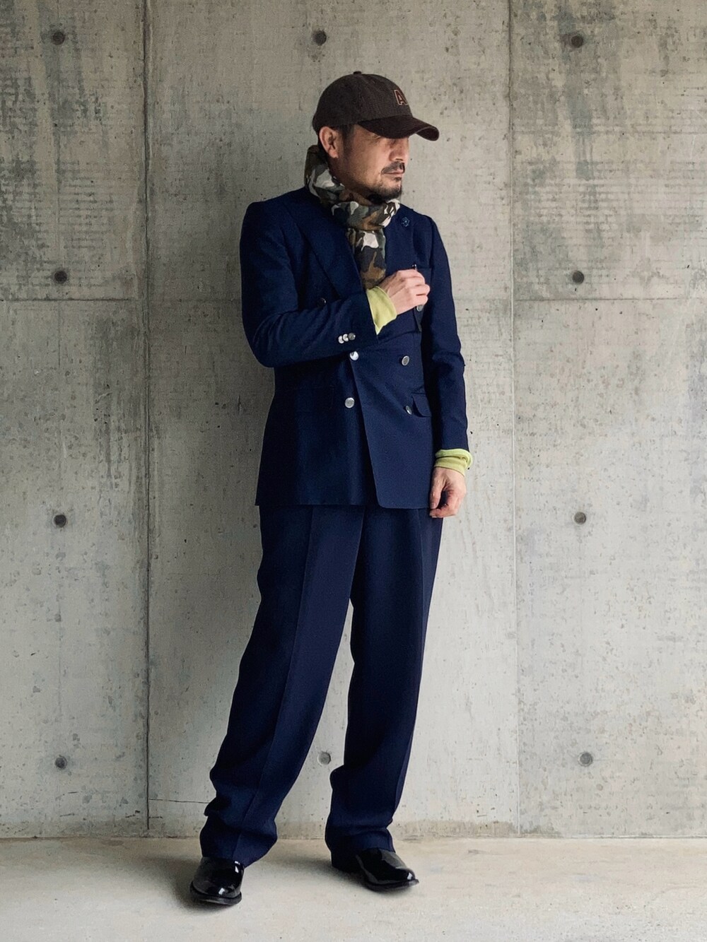 ブルー系のテーラードジャケット、ブルー系のスラックス、グリーン系のポロシャツを着用したメンズの冬コーディネートの3枚目の写真