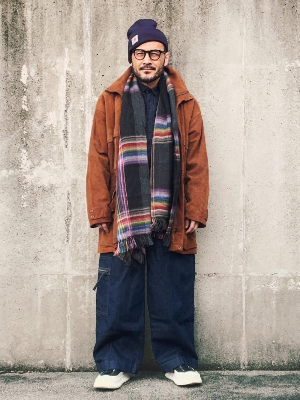 ブラック系のスニーカー、ブラウン系のその他アウター、ブルー系のデニムパンツを着用したメンズの冬コーディネートの3枚目の写真