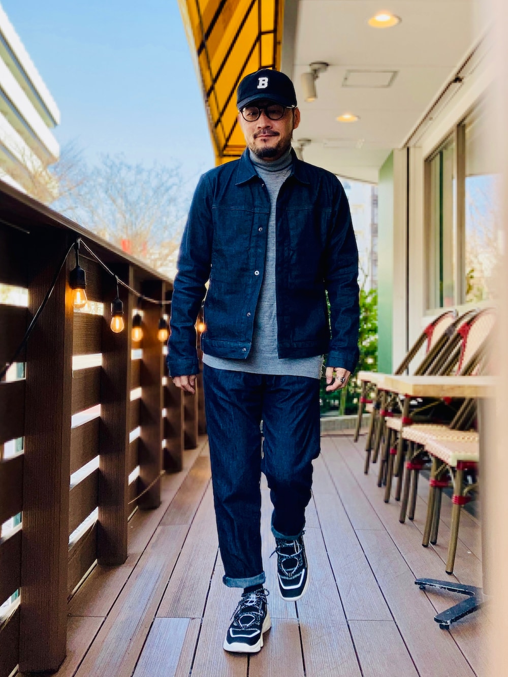 グレー系のニット/セーター、ブルー系のデニムジャケット、ブルー系のデニムパンツを着用したメンズの春コーディネートの2枚目の写真