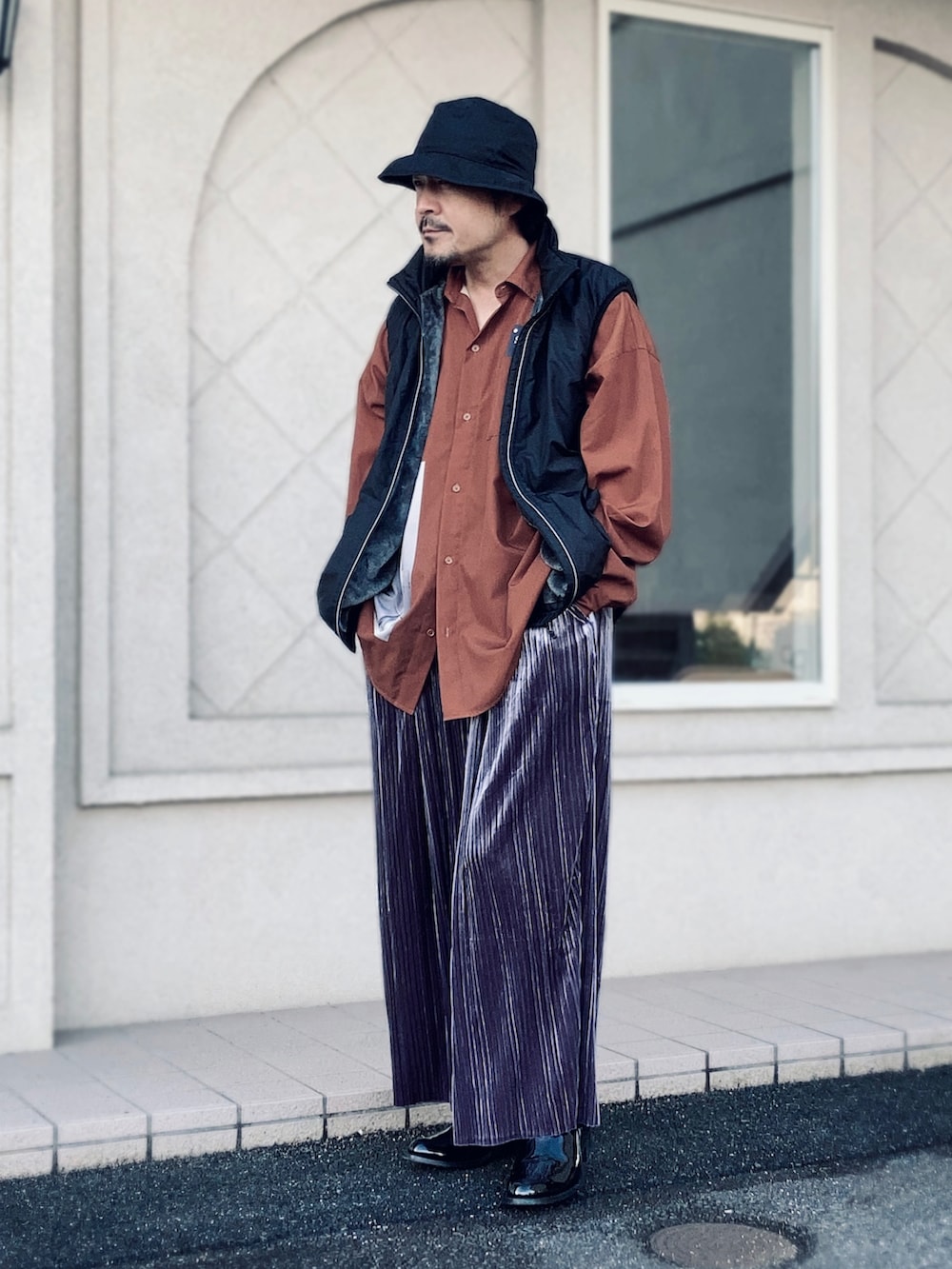 オレンジ系のシャツ/ブラウス、ブラック系のベスト、グレー系のその他パンツを着用したメンズの秋コーディネートの4枚目の写真