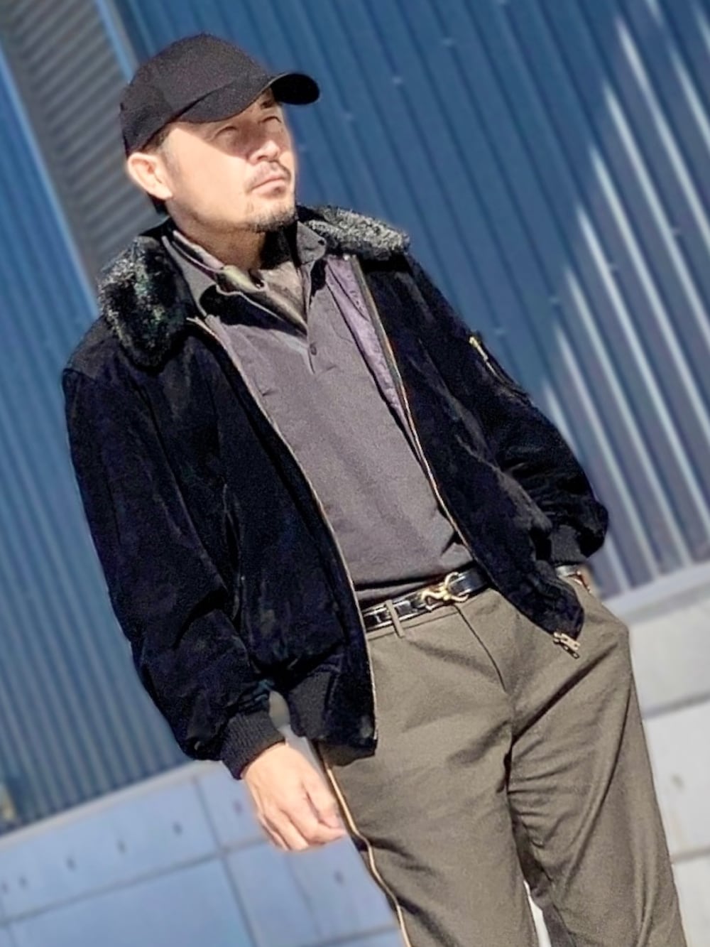 ブラック系のポロシャツ、ブラック系のブルゾン、グリーン系のスラックスを着用したメンズの秋コーディネートの3枚目の写真