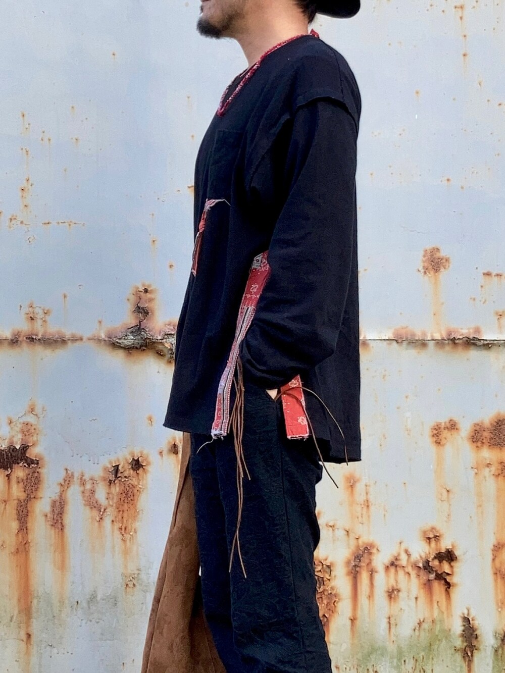 ブラック系のTシャツ/カットソー、ブラック系のその他パンツ、レッド系のブーツを着用したメンズの春コーディネートの2枚目の写真