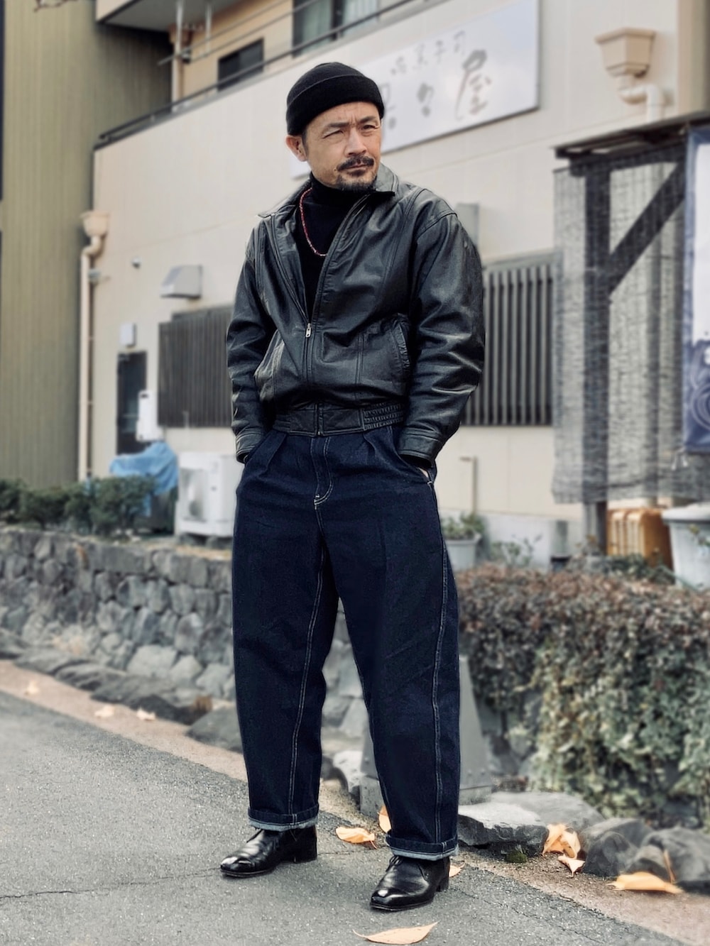 ブラック系のニット/セーター、ブラック系のブルゾン、ブルー系のデニムパンツを着用したメンズの冬コーディネートの2枚目の写真