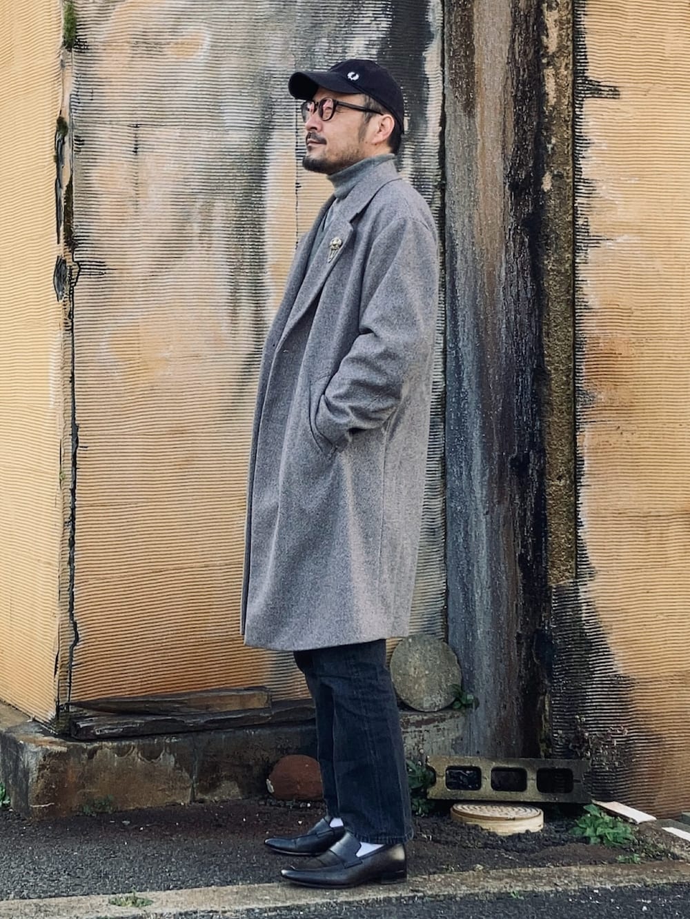 グレー系のニット/セーター、グレー系のニット/セーター、グレー系のチェスターコートを着用したメンズの冬コーディネートの3枚目の写真