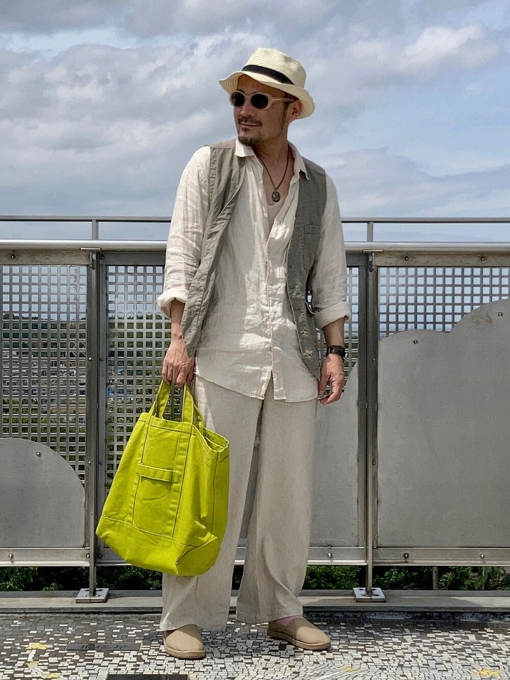 ベージュ系のシャツ/ブラウス、グリーン系のベスト、ベージュ系のパンツを着用したメンズの春コーディネートの4枚目の写真