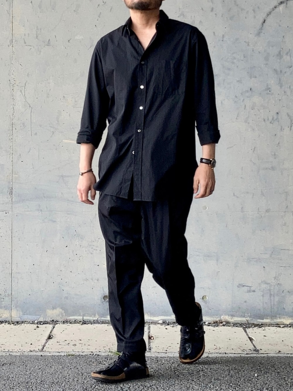 ブラック系のシャツ/ブラウス、ブラック系のスラックス、ブラック系のサンダルを着用したメンズの春コーディネートの4枚目の写真