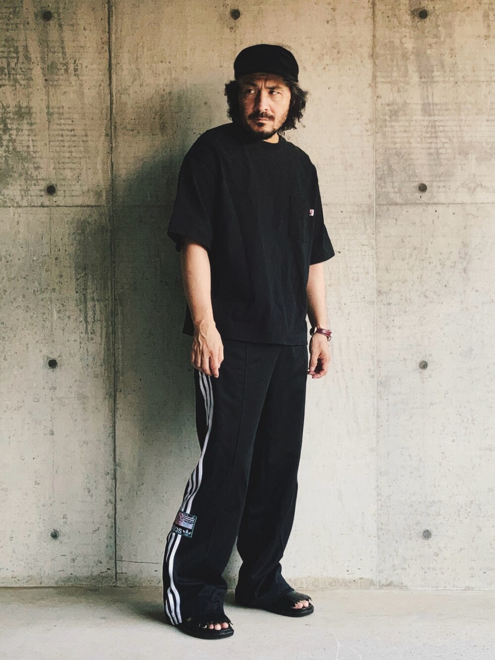 ブラック系のスウェットパンツ、ブラック系のTシャツ/カットソー、ブラック系のサンダルを着用したメンズの夏コーディネートの3枚目の写真