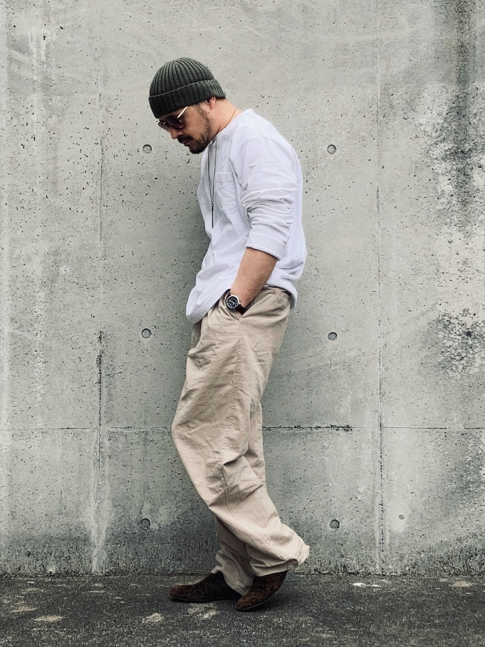 ホワイト系のTシャツ/カットソー、ベージュ系のスラックス、ブラウン系のスリッポンを着用したメンズの春コーディネートの3枚目の写真