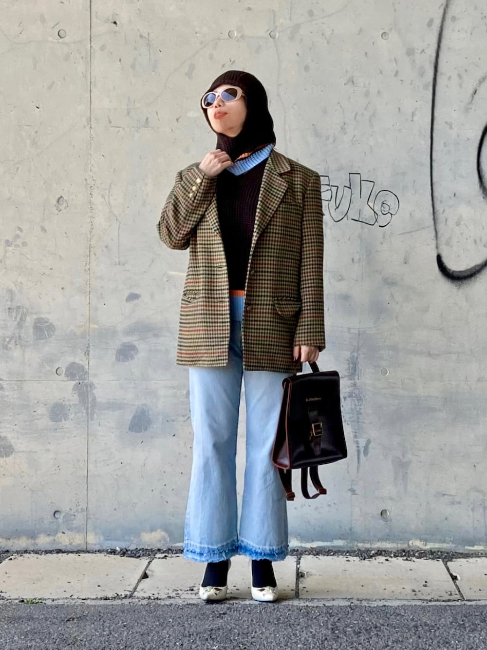 ブラウン系のベスト、ベージュ系のテーラードジャケット、ブラウン系のバックパック/リュックを着用したレディースの春コーディネートの2枚目の写真