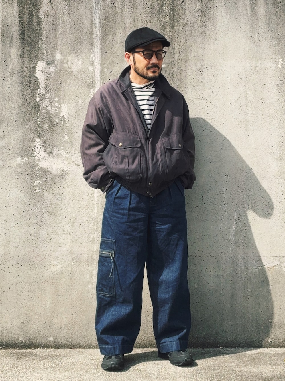 ブラック系のTシャツ/カットソー、グレー系のブルゾン、ブルー系のデニムパンツを着用したメンズの春コーディネートの2枚目の写真