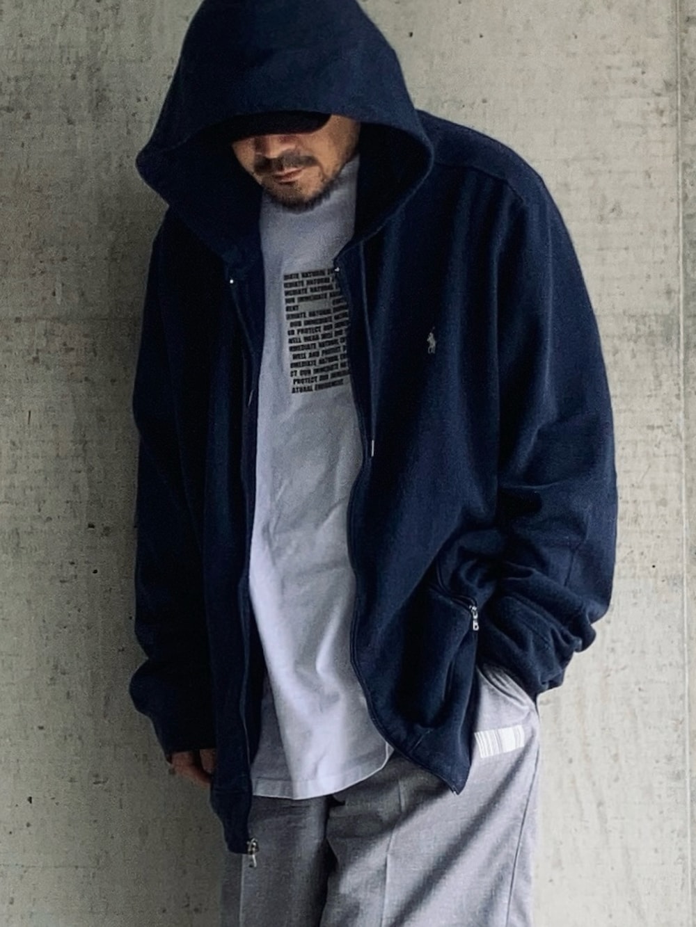 ホワイト系のTシャツ/カットソー、グレー系のスラックス、ブラック系のローファーを着用したメンズの春コーディネートの3枚目の写真