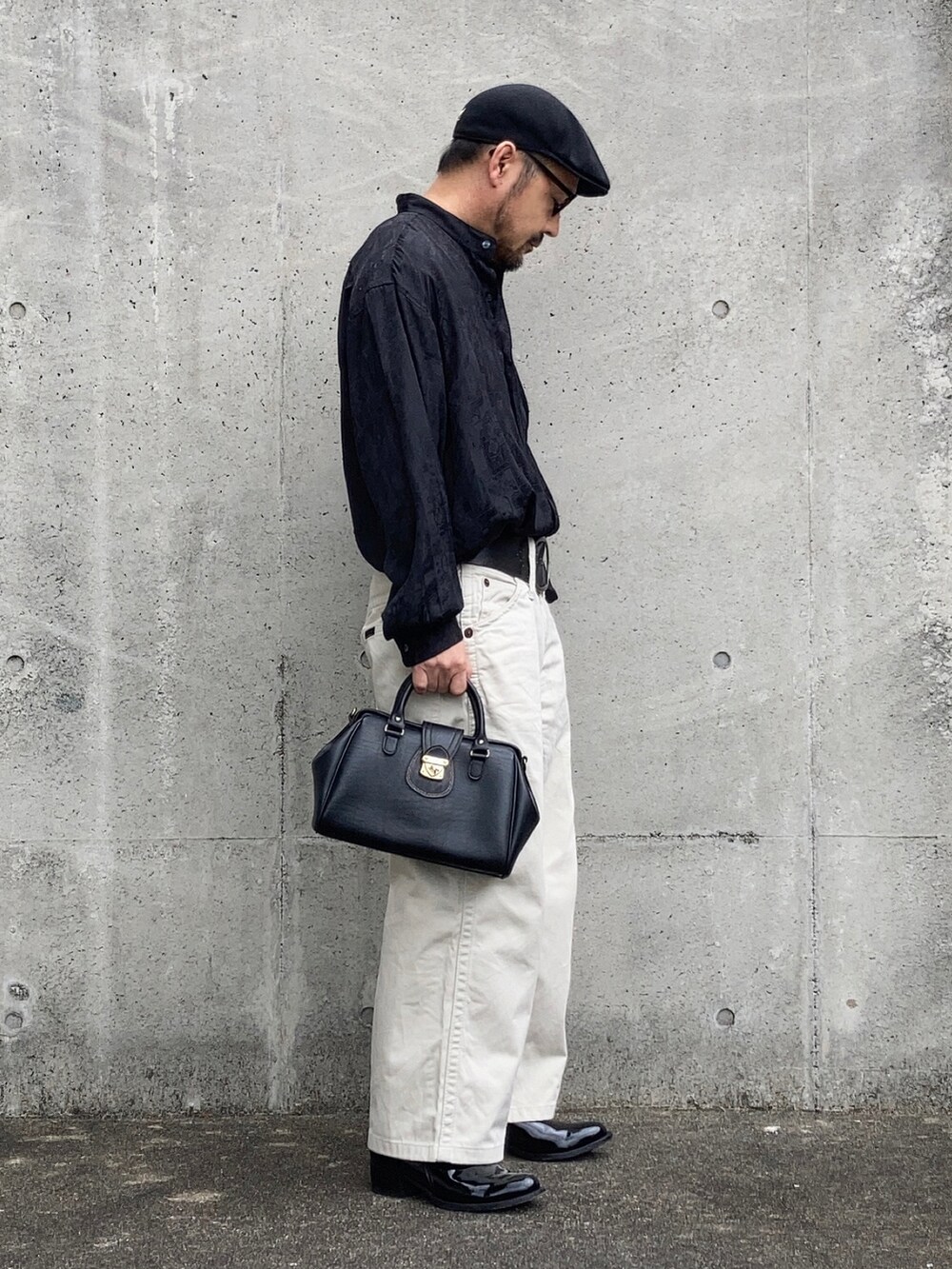 ホワイト系のデニムパンツ、ブラック系のシャツ/ブラウス、ブラック系のブーツを着用したメンズの春コーディネートの2枚目の写真