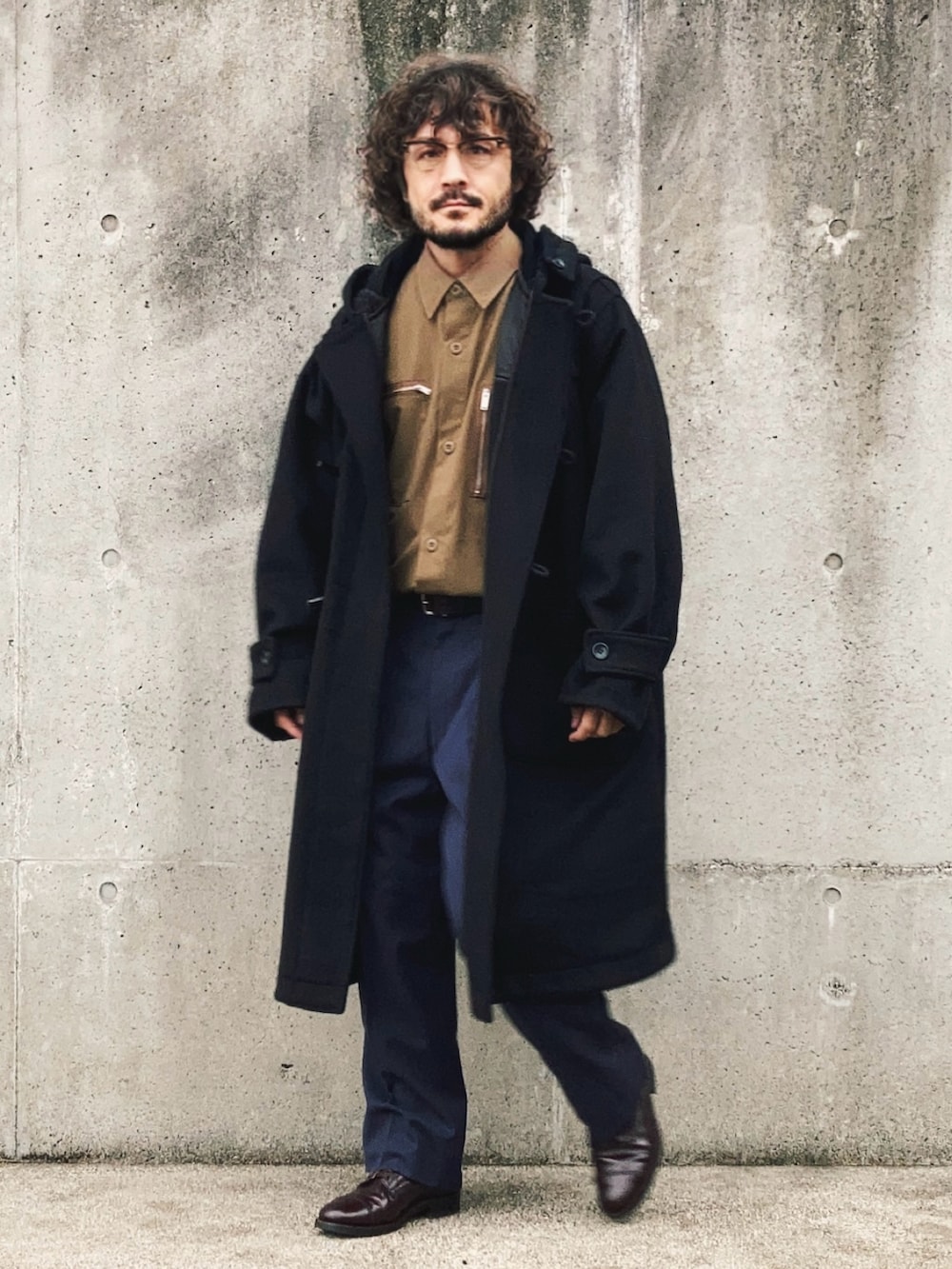 ブラック系のダッフルコート、ベージュ系のセットアップ、ブルー系のスラックスを着用したメンズの秋コーディネートの2枚目の写真