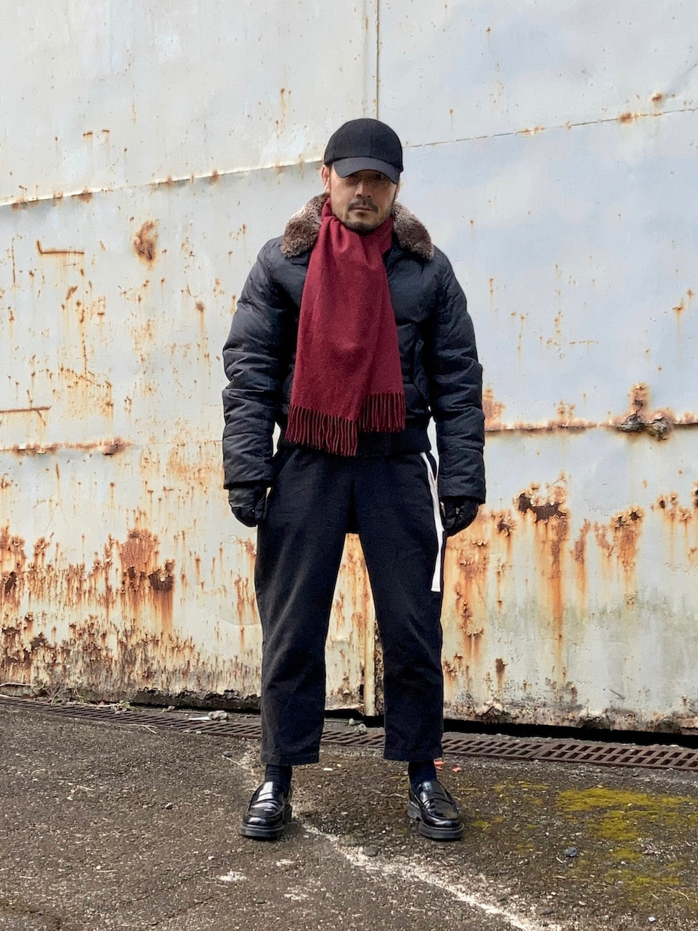 ブラック系のダウンジャケット/コート、ブラック系のその他パンツ、ブラック系のローファーを着用したメンズの冬コーディネートの2枚目の写真