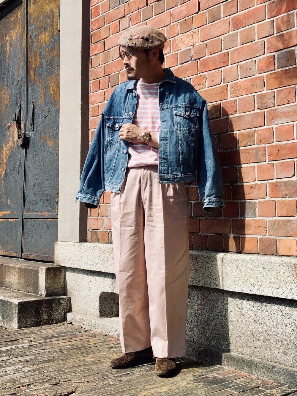 ピンク系のTシャツ/カットソー、ブルー系のデニムジャケット、ピンク系のスラックスを着用したメンズの秋コーディネートの4枚目の写真