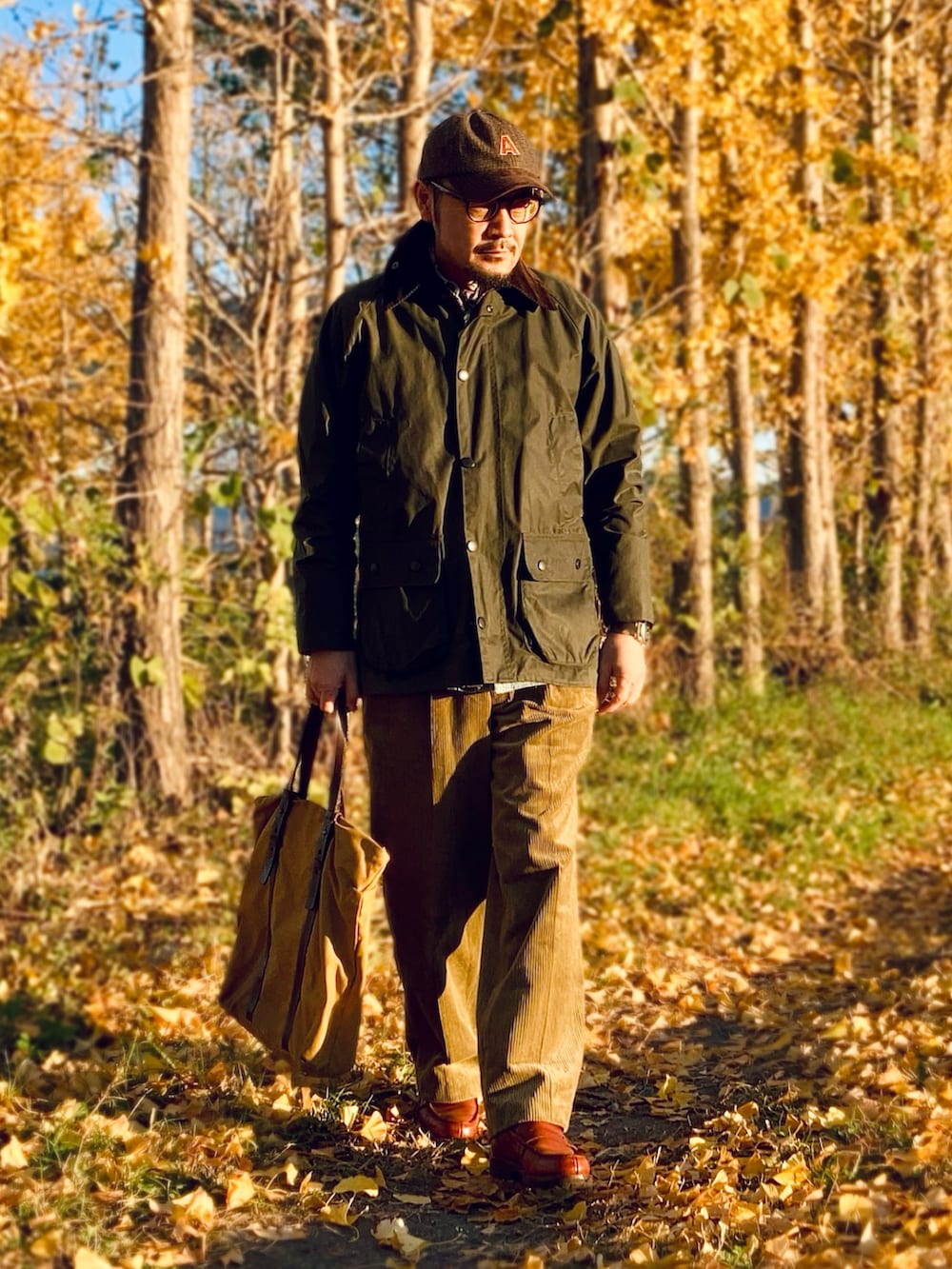 ブルー系のシャツ/ブラウス、ゴールド系のスラックス、ブラウン系のローファーを着用したメンズの冬コーディネートの3枚目の写真