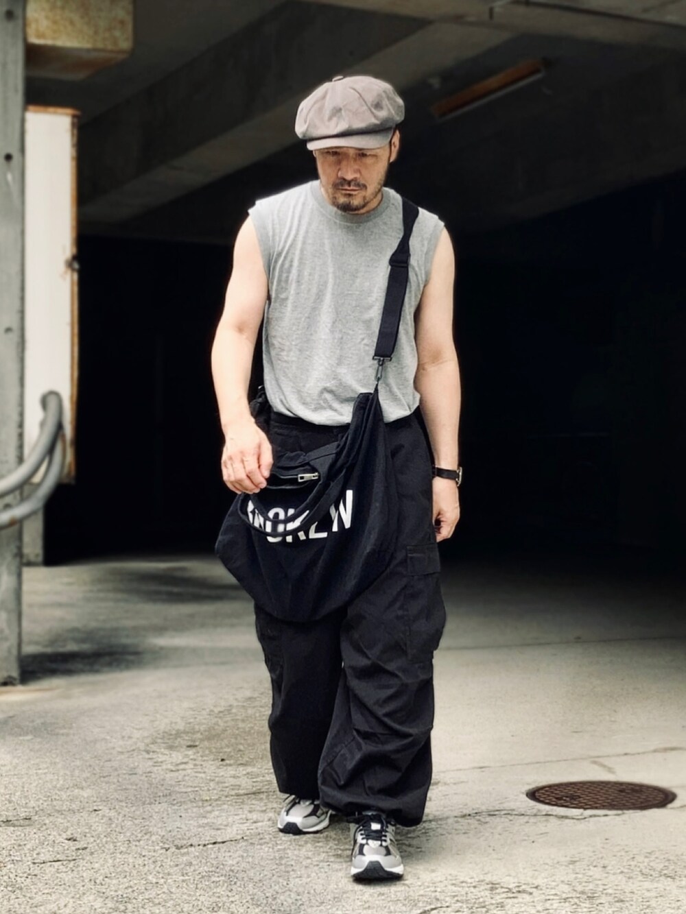 グレー系のTシャツ/カットソー、ブラック系のカーゴパンツ、ブラック系のスニーカーを着用したメンズの夏コーディネートの5枚目の写真